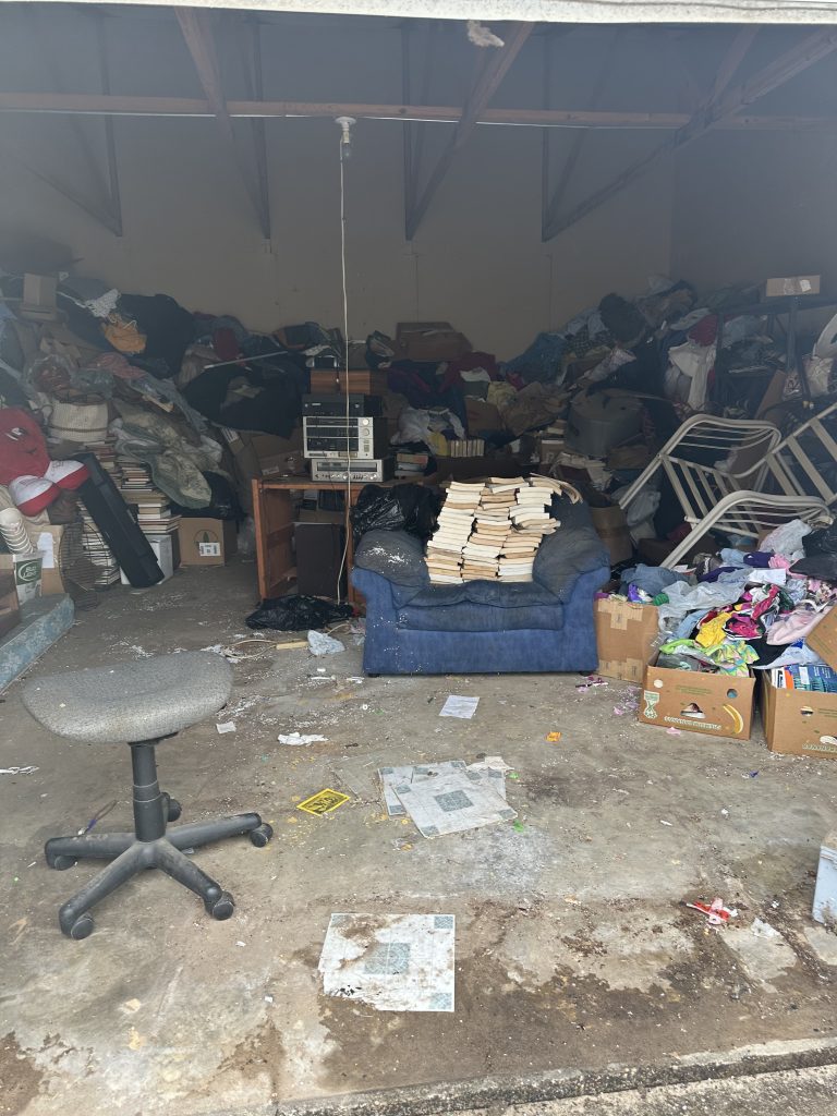 Garage Cleanout crew removing boxes tools furniture and debris from a cluttered garage