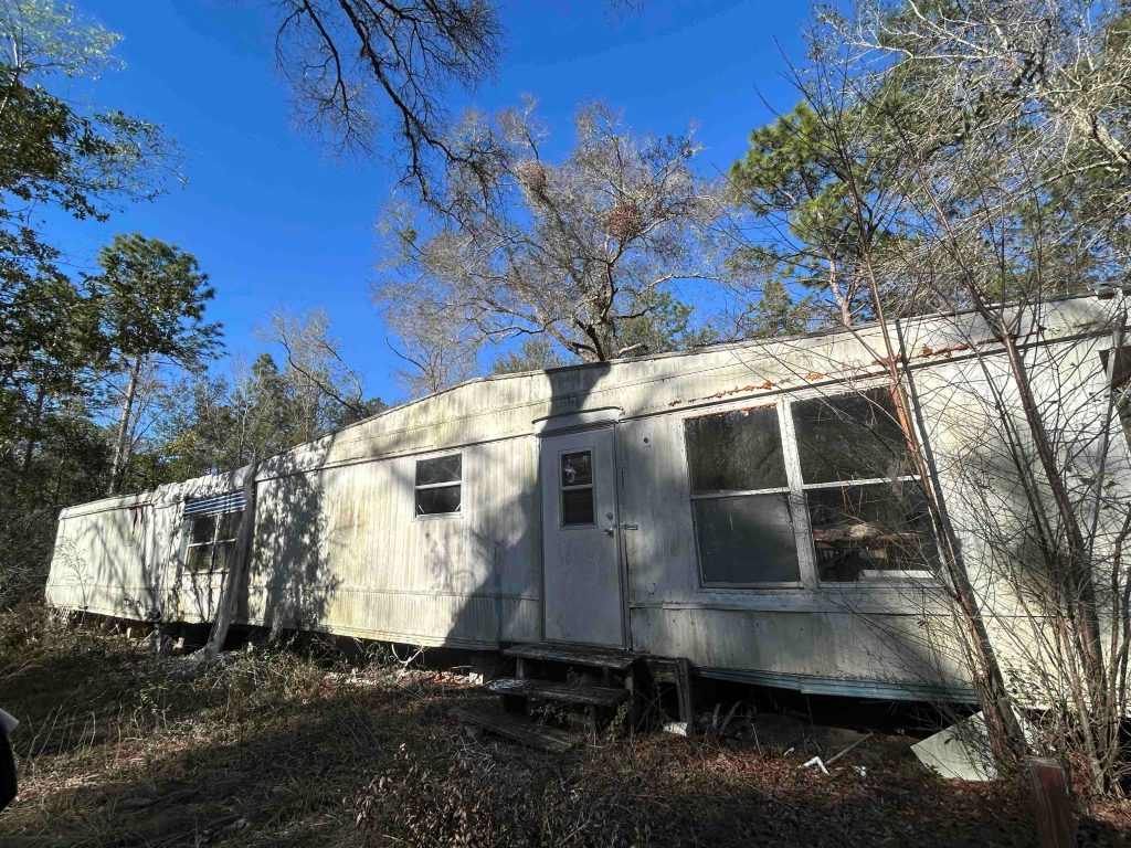 Mobile Home Removal crew demolishing and hauling away an old manufactured home
