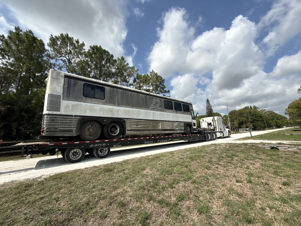 RV Removal crew hauling away an old motorhome and travel trailer